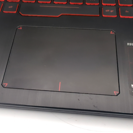 Close-up of a laptop touchpad and keyboard, featuring ASUS TUF Gaming branding and specifications label.