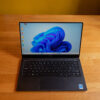 Dell laptop displaying Windows 11, shown on a wooden desk from above.