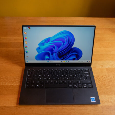 Dell laptop displaying Windows 11, shown on a wooden desk from above.