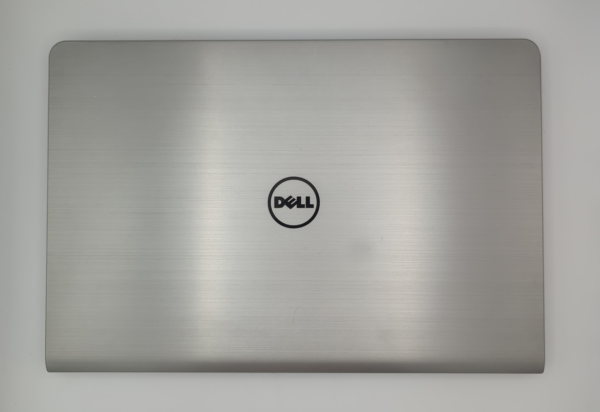 Silver Dell laptop closed on white background. Sleek minimalist design with Dell logo centered.