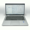 Silver laptop with Windows operating system displayed, showing system settings and device specifications.