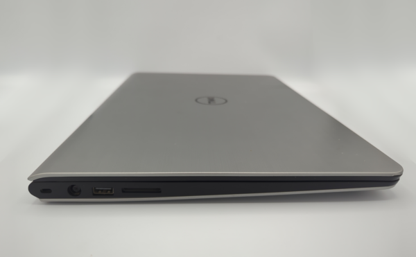 Closed silver laptop with visible USB and charging ports on the side, against a white background.
