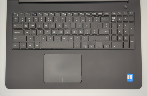 Black laptop keyboard with numeric keypad and touchpad, featuring Windows 10 sticker in the bottom-right corner.