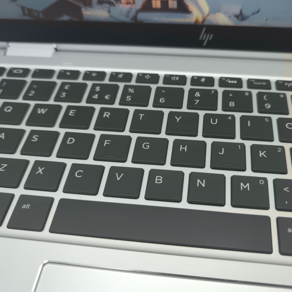 Close-up of a laptop keyboard with black keys and a silver frame, featuring a QWERTY layout.