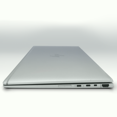 Slim silver laptop viewed from the side, showcasing ports and sleek design. Ideal for tech reviews and product features.
