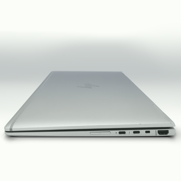 Slim silver laptop viewed from the side, showcasing ports and sleek design. Ideal for tech reviews and product features.