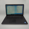 Dell laptop displaying system specifications on screen, featuring Windows operating system in a bright setting.