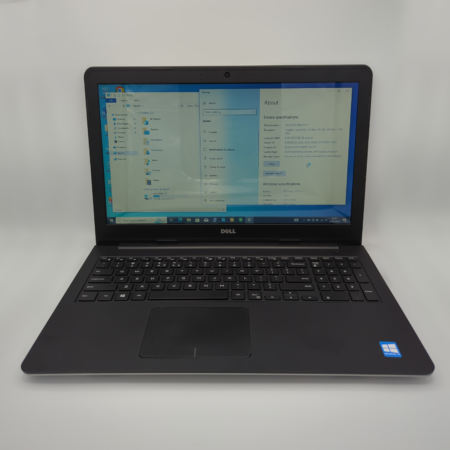 Dell laptop displaying system specifications on screen, featuring Windows operating system in a bright setting.