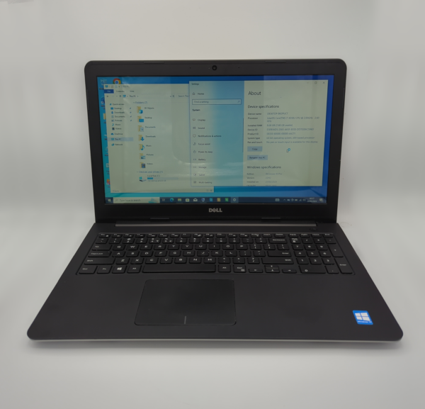Dell laptop displaying system specifications on screen, featuring Windows operating system in a bright setting.