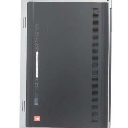 Bottom view of a closed laptop showcasing ventilation and branding labels on a white surface.