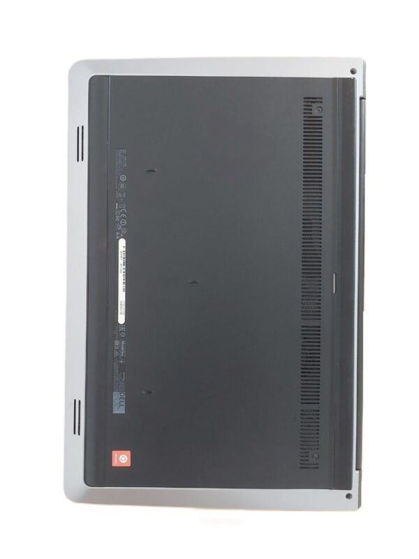 Bottom view of a closed laptop showcasing ventilation and branding labels on a white surface.