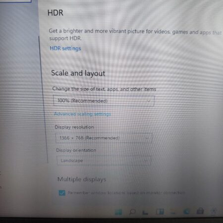 Adjusting display settings on a Windows computer, including HDR, scaling, and resolution options.