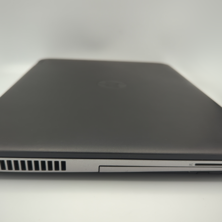 Closed black laptop on a white background, showing side detail with ports and vents.