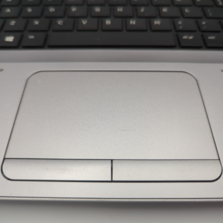 Close-up of a laptop touchpad and keyboard, highlighting ergonomic design and functionality.