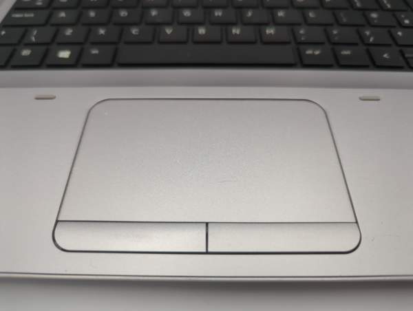 Close-up of a laptop touchpad and keyboard, highlighting ergonomic design and functionality.