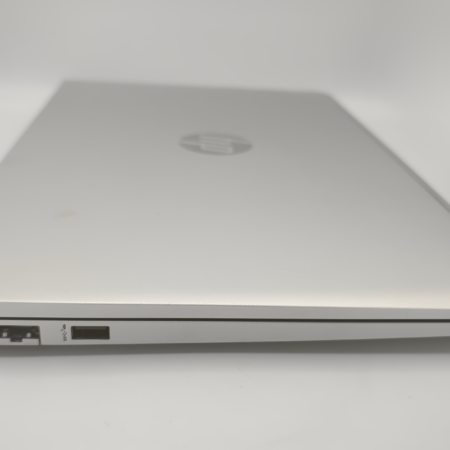 Closed silver laptop showing Ethernet and USB ports on a white background.