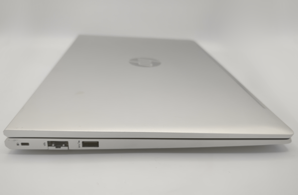 Closed silver laptop showing Ethernet and USB ports on a white background.