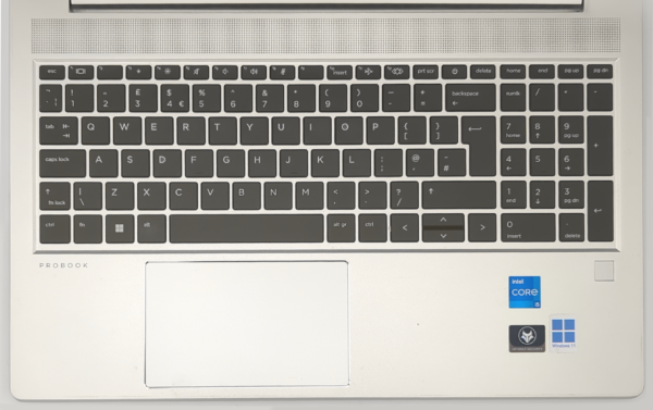Silver laptop keyboard with Intel Core i5 and Windows 11 stickers, showing a numeric keypad and touchpad.