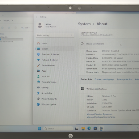 Laptop screen displaying system specifications and Windows 11 details on the settings panel.