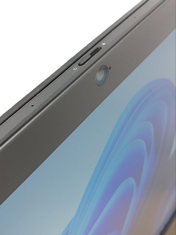 Close-up of a laptop webcam with privacy cover, screen displaying blue abstract pattern.