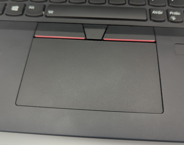 Close-up of a laptop touchpad with black and red accents, highlighting the keyboard's lower section.