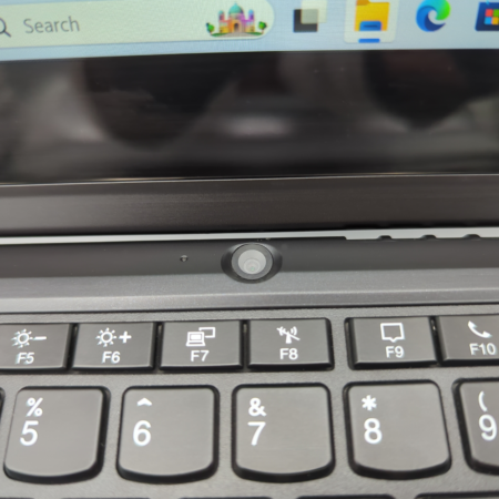 Close-up of a laptop keyboard and webcam, showcasing function keys and a sleek design.