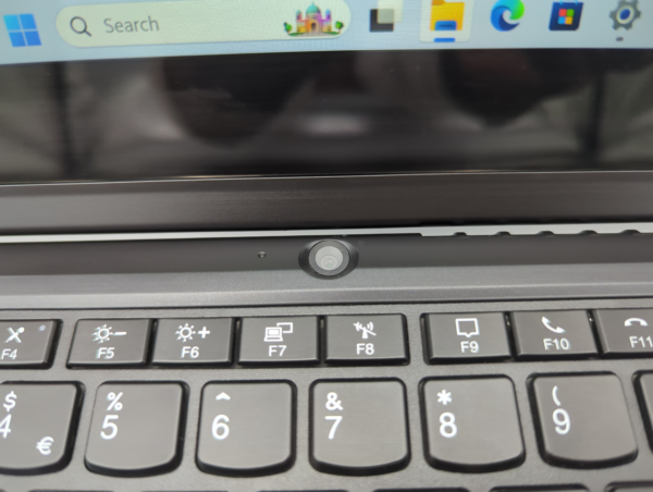 Close-up of a laptop keyboard and webcam, showcasing function keys and a sleek design.