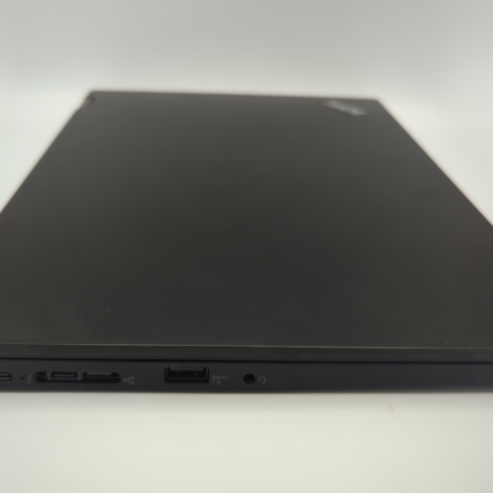 Closed black laptop with visible USB ports on a white background.
