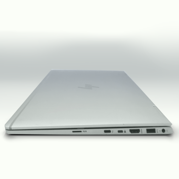 Closed silver laptop with various ports and sleek design on a light background.