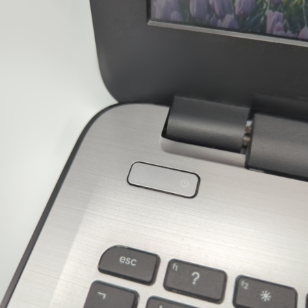 Close-up of a laptop power button next to keyboard keys, highlighting technology and functionality.