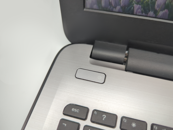 Close-up of a laptop power button next to keyboard keys, highlighting technology and functionality.
