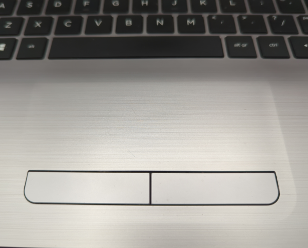 Close-up of a laptop touchpad with keyboard, highlighting navigation controls and button details.
