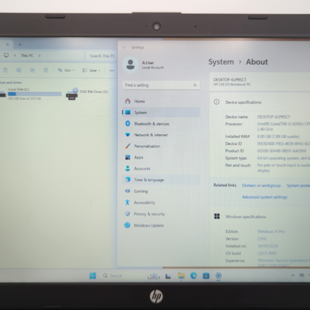 Open laptop displaying Windows system specifications and file explorer.
