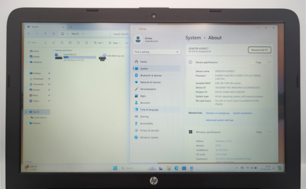 Open laptop displaying Windows system specifications and file explorer.