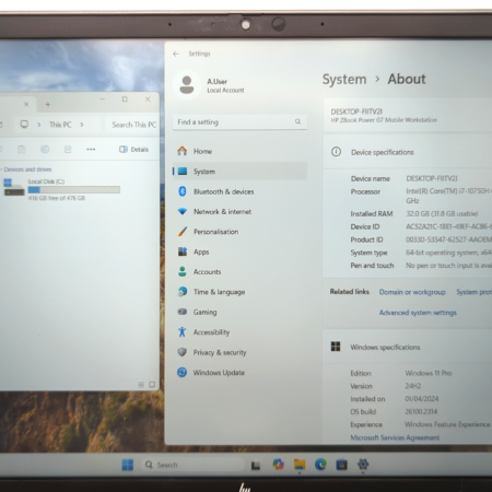 Laptop displaying Windows 11 system information and local disk space with applications visible on the desktop.