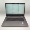 Laptop with Windows 11 displaying system info, open on a clean white surface.