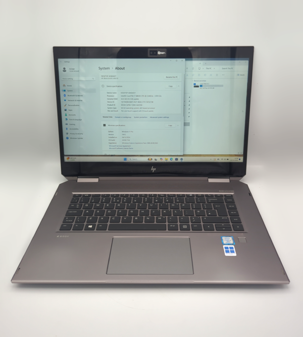 Laptop with Windows 11 displaying system info, open on a clean white surface.