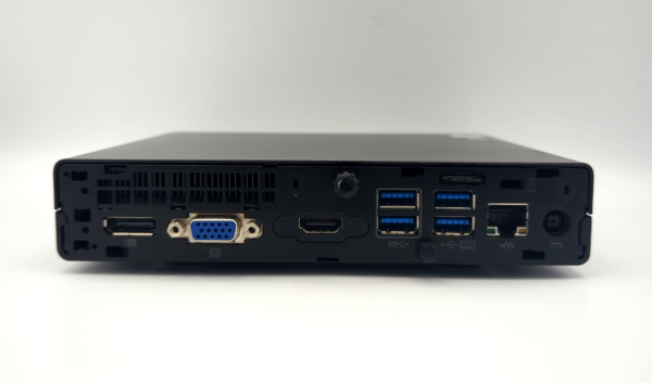 Back view of a black mini PC showing various ports including HDMI, USB, VGA, Ethernet, and power connector.