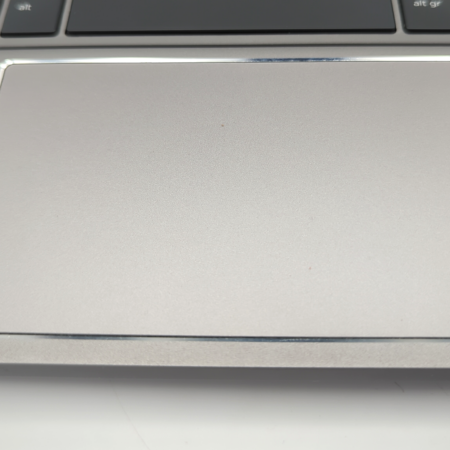 Laptop touchpad close-up next to keyboard, showcasing sleek design and smooth surface.