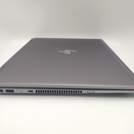 Silver closed laptop showing side ports and vents on a white background.