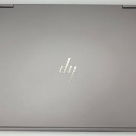 Closed HP laptop with logo on silver lid, top view.