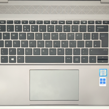 Laptop keyboard with Intel Core i7 and Windows 11 stickers, featuring a sleek design and wide touchpad.