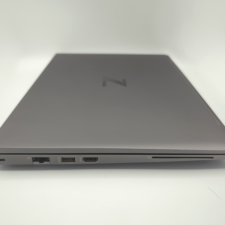 Closed gray laptop side view showing ports, including USB and HDMI connections, on a white background.