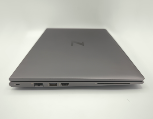 Closed gray laptop side view showing ports, including USB and HDMI connections, on a white background.