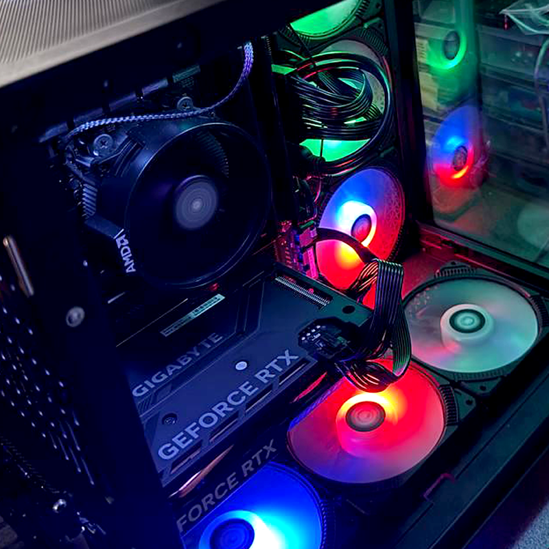 Gaming PC setup with RGB lights, Geforce RTX graphics card, and AMD cooling system. High-performance hardware.
