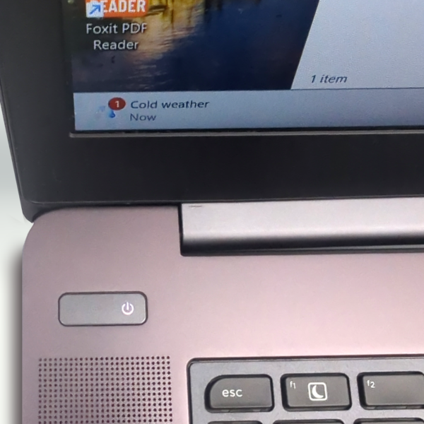 Laptop displaying Foxit PDF Reader and cold weather notification on screen.
