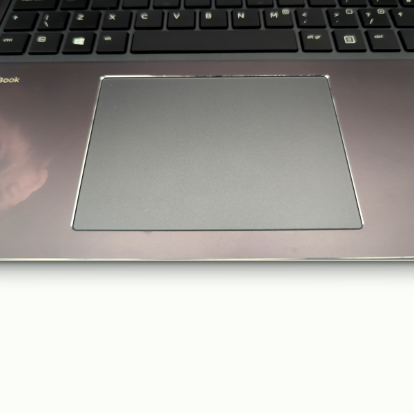 Laptop touchpad close-up with keyboard in the background.